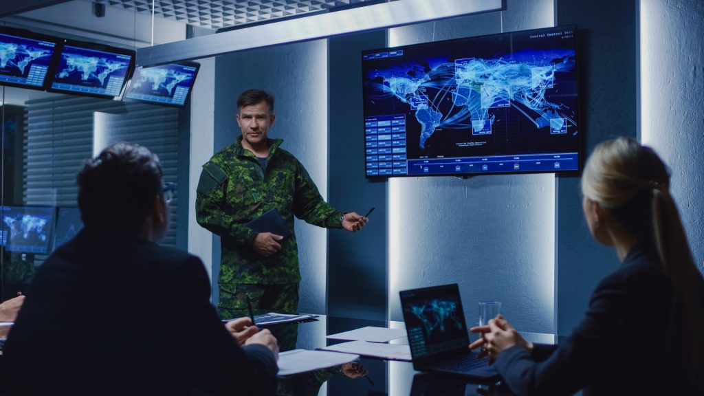 High-Ranking Military Man holds a Briefing to a Team of Governme